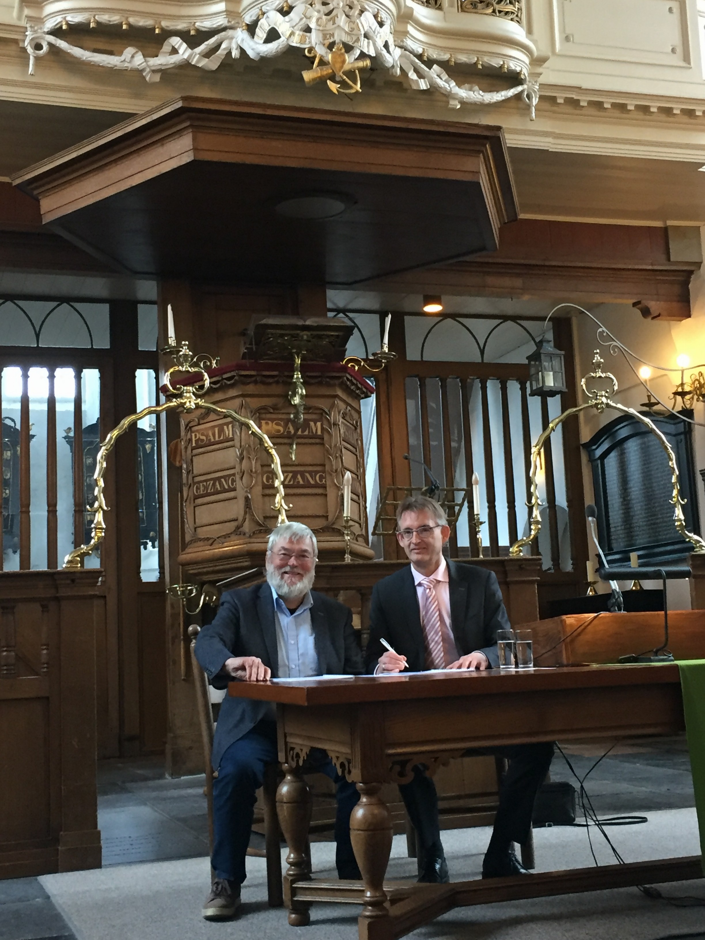 Orgelmaker Hans van Rossum (l) en kerkrentmeester Dick Oosthoek tekenen het contract voor de restauratie van het G.Th. Bätz-orgel (1787) in Breukelen; vrijdag 26 januari 2018.